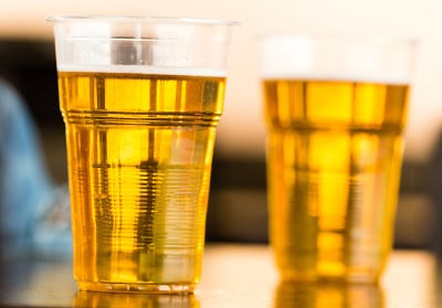 桌上放着塑料杯里的新鲜啤酒
