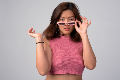 年轻美丽的亚洲女人摘下新奇眼镜的肖像