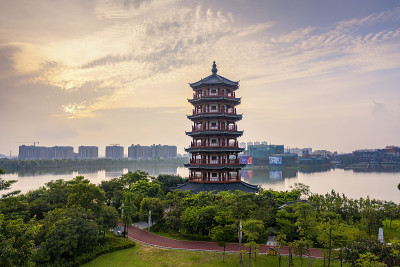 清晨的阳光照在公园湖边的高塔上