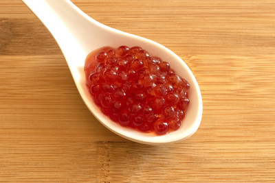 白色汤匙与红色鱼子酱分离