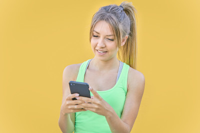 漂亮的金发女孩用手机发短信