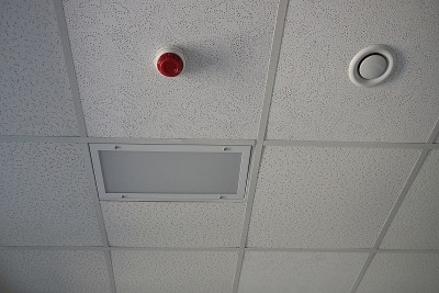 灰色天花板上有两个圆形塑料报警器