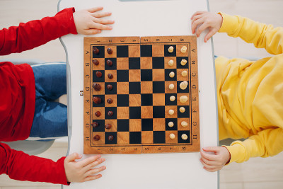 在幼儿园或小学下棋的小孩。俯视图