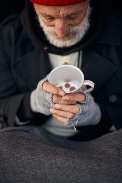 俯视图上的乞丐高级男子与杯与一些硬币在底部