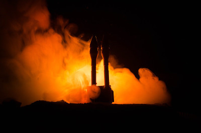 火箭发射与火云。携带核弹头的核导弹在夜晚瞄准灰暗的天空。弹道火箭战争背景。世界大战警报