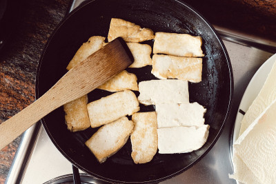 豆腐在黑色平底锅中煸炒