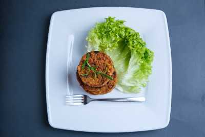 盘子里的油炸蔬菜肉饼。由土豆、青豆、胡萝卜和青豆做成的美味馅饼，配以新鲜的青葱。素食午餐或晚餐的主意