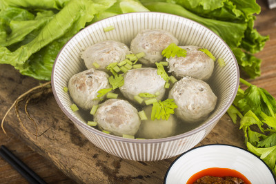 木板背景上的一碗牛肉丸子汤