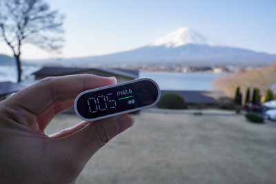 手持便携式空气质量检测仪与富士山或富士山在川口湖，日本。