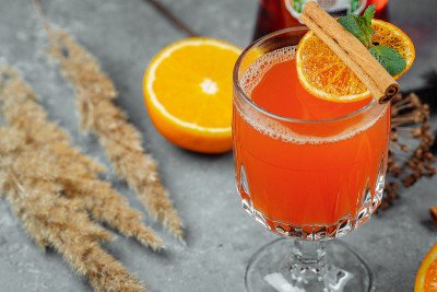 温暖的冬季鸡尾酒与aperol。热aperol。新年和圣诞节的鸡尾酒。圣诞冬季鸡尾酒，配上菠萝汁和香