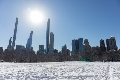 在纽约市的冬天，从中央公园白雪覆盖的绵羊草地上看曼哈顿中城的天际线