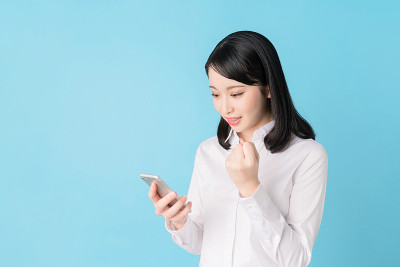 年轻的亚洲女孩在用智能手机。