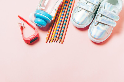 孩子们的衣服和学习用品:运动鞋、铅笔、一瓶水和电子gps手表。