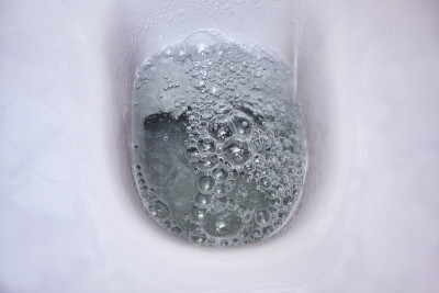 在白色马桶的碗里冲水