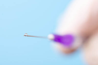 医生拿着装有疫苗的注射器进行注射