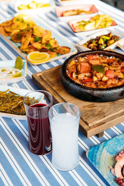 烤鱼、沙拉和蔬菜。海鲜，烤肉，meze, raki, ouzo，开胃菜和沙拉在希腊或土耳其鱼餐厅的桌