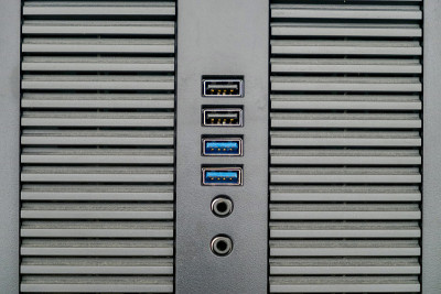 灰色沙面电脑机箱设计前面板，蓝色usb3，黑色usb接口和音频，麦克风连接器。