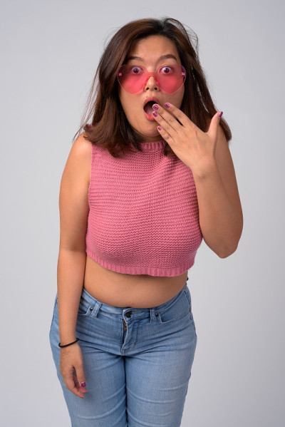 一位戴着心形眼镜的年轻亚洲女子看起来很震惊