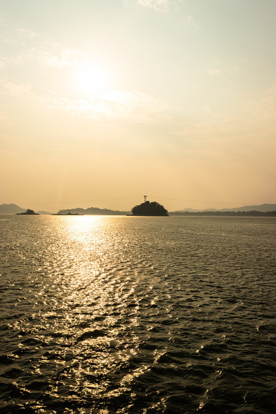 夕阳橙色的天空与河岛的背景在黄昏