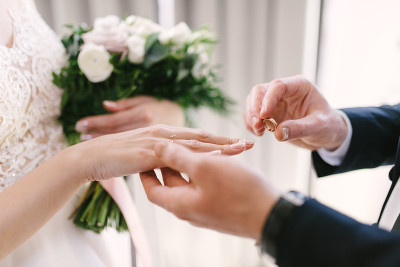 新郎把结婚戒指戴在新娘身上。新娘给新郎戴上结婚戒指。