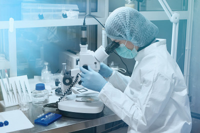 年轻的科学家在实验室里通过显微镜观察。医学研究实验室。