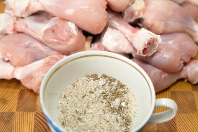 香料、盐、胡椒、豆蔻、齐拉在一个罐子里，背景是鸡肉