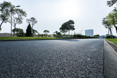 高大的城市柏油路穿过绿色的草地。