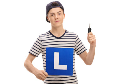 一个拿着l牌和车钥匙的少年