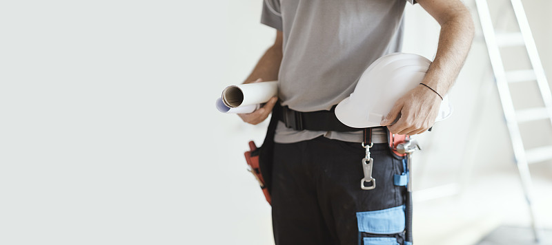 建筑工程师拿着安全帽和工程