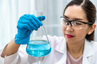 女化学科学家拿着烧瓶和在实验室用设备进行实验，科学概念