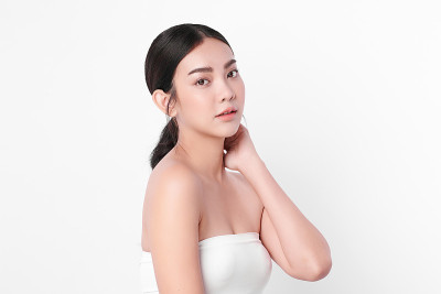美丽年轻的亚洲女性与干净的新鲜皮肤在白色的背景，面部护理，面部治疗，美容和水疗中心，亚洲女性肖像。
