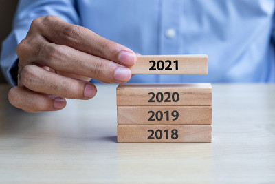 商人手拉2021木制积木在桌子的背景。商业计划，风险管理，决议，战略，解决方案，目标，新年，新年你和