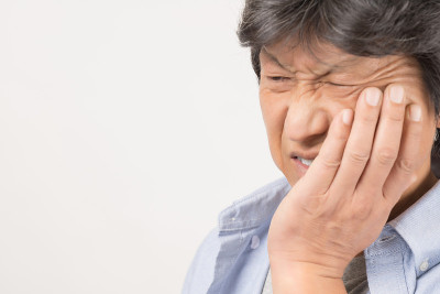 中年男子因牙痛捂着脸颊