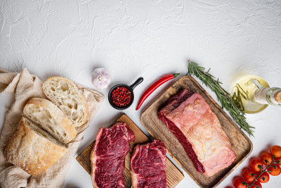 牛排汉堡的原料与牛肉大理石肉，在白色背景，俯视图，与复制空间的文字