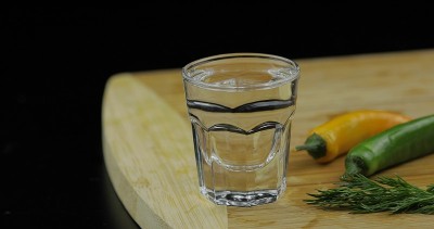 用小酒杯盛着的伏特加酒和辣椒放在砧板上