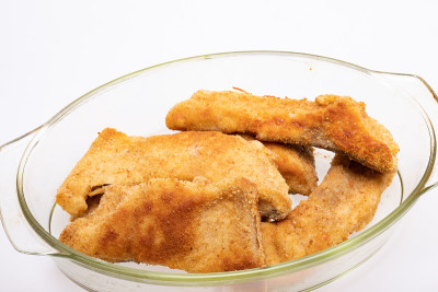裹有面包屑的鱼片，盛在耐热玻璃器皿中