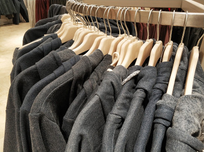 在服装店挂衣服，夹克和帽衫