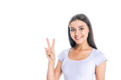 一个快乐的女人的肖像显示和平标志孤立在白色