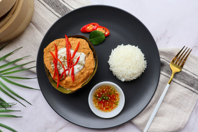 香蕉叶杯蒸咖喱鱼配白米饭和辣味鱼露-著名的泰国食物叫Hor Mok或Amok在大理石桌子上俯视