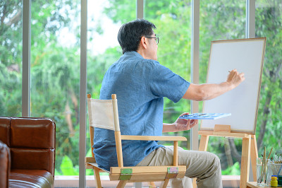 退休的亚洲老人正在休息、画画、爱好