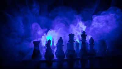 棋牌游戏的商业理念和竞争理念或战略理念。象棋人物在黑暗色调的雾背景上。