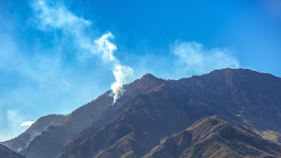在鲜艳的蓝天下，犹他州的秃山着火了