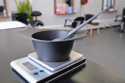 搅拌碗和染发剂刷在电子秤上。染发剂测量和混合工具。染发工具套装。染发师和发型师的专业仪器。