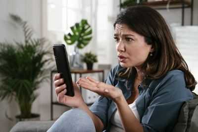 一个可悲的女人，坐在沙发上打电话