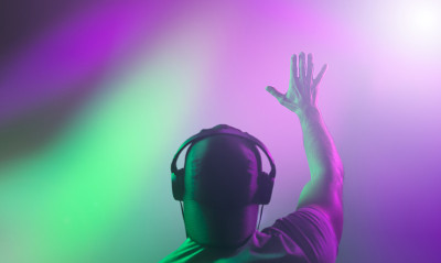 DJ在一场表演中举起了手。后视图