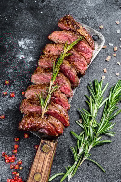 烤裙子，大砍刀牛排。大理石肉牛肉。黑色背景。俯视图