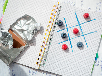 在学校的午餐休息时间用浆果和巧克力棒来玩井字游戏。趣味而快乐地学习