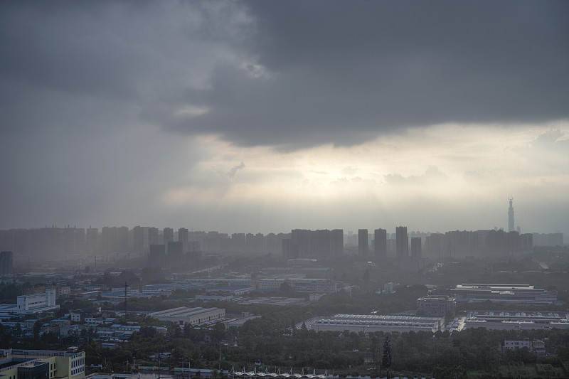 太阳在雨中穿过云层形成潮汐效应的城市