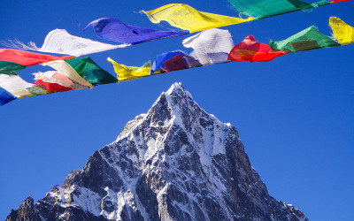 五彩的经幡后面是一座雪山。