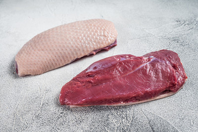 肉铺上的生鸭胸肉排。白色背景。俯视图